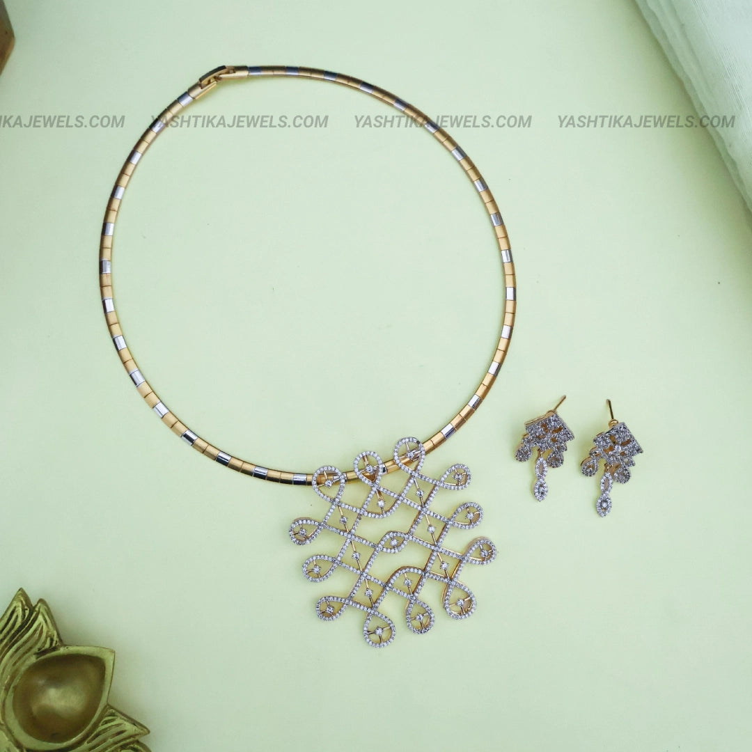Gold-tone pendant necklace with geometric American diamond stone-studded pendant, two-tone chain and matching drop earrings.