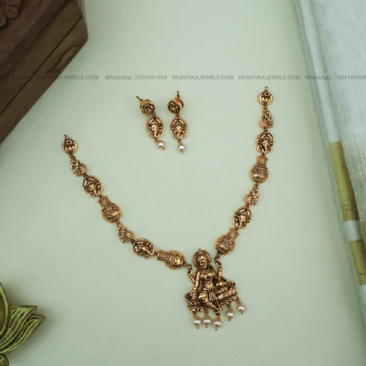 Antique gold Goddess Lakshmi pendant necklace with traditional motifs and pearl drop matching earrings