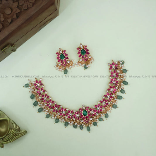 Pink and green Jadau floral necklace set made with brass and antique gold finish with pearl and green bead drops